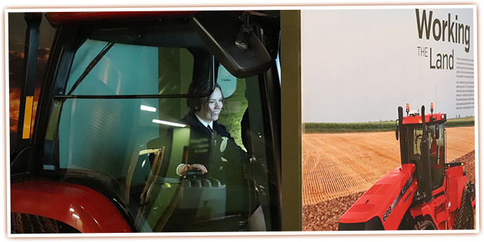Oregon FFA Officers try driving a tractor at this interactive exhibit at the SAGE Center